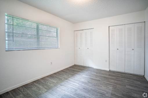 A room with a window and a wooden floor.