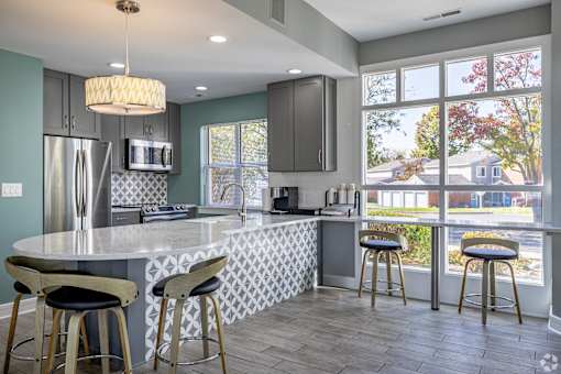 A kitchen with a large island and bar stools.