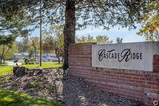 A sign that says Cascade Ridge is on a brick wall.