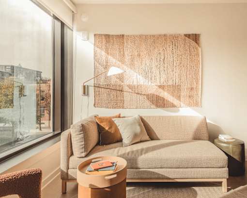 a living room with a couch and a window at Scout Living, powered by Placemakr Apartments, Atlanta, GA
