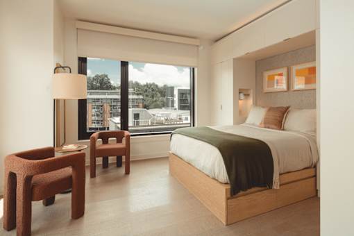 a hotel room with a bed and a window at Scout Living, powered by Placemakr Apartments, Atlanta, GA