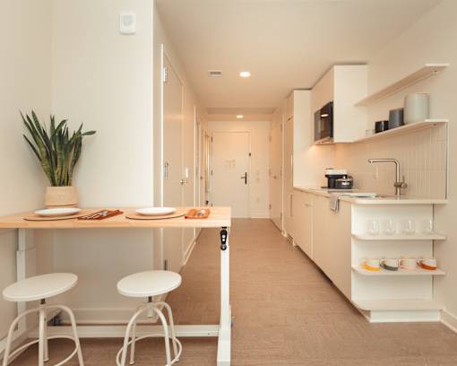 a small kitchen with a table and stools at Scout Living, powered by Placemakr Apartments, Atlanta, 30308
