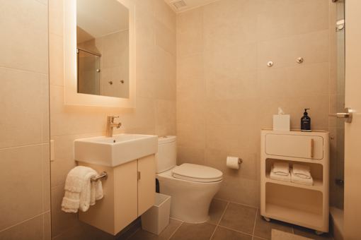 a bathroom with a toilet and a sink and a mirror at Scout Living, powered by Placemakr Apartments, Georgia 30308