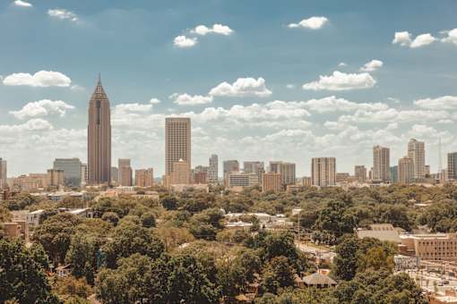 the skyline of the city with a blue cloudy sky and trees at Scout Living, powered by Placemakr Apartments, Atlanta, 30308