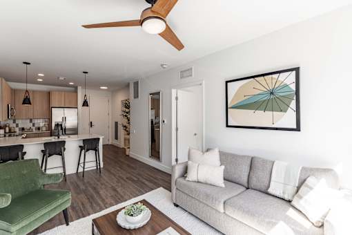 A living room with a green couch and a ceiling fan at Anthem House Apartment , Huntsville, 35806