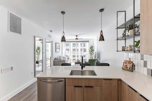 A modern kitchen with a stainless steel dishwasher and wooden cabinets at Anthem House Apartment , Alabama, 35806