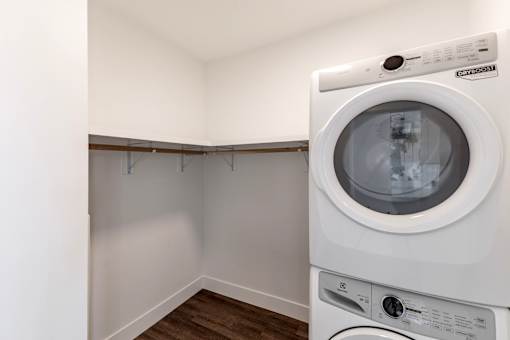 A white washing machine in a small laundry room at Anthem House Apartment , Huntsville, AL