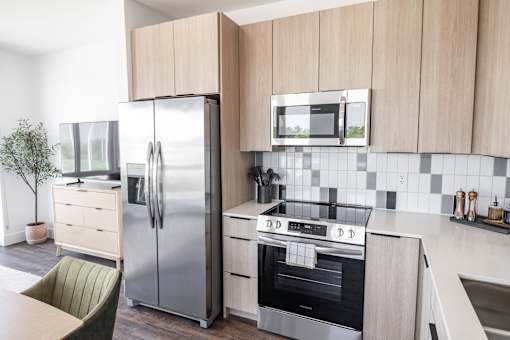 A modern kitchen with a stainless steel refrigerator, oven, and microwave at Anthem House Apartment , Huntsville, 35806