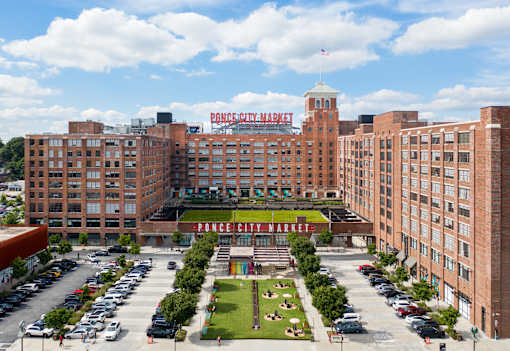 an aerial view of a large brick building with a large sign on top of it at Scout Living, powered by Placemakr Apartments, Georgia