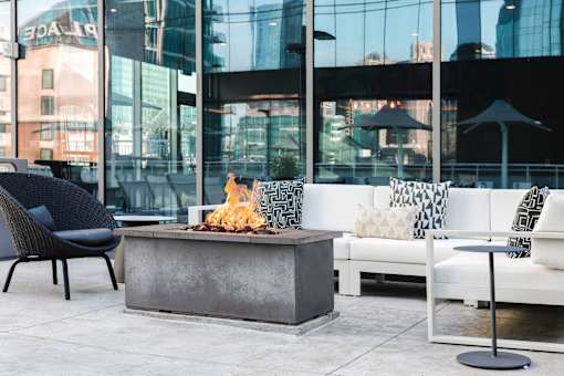 A patio with a fire pit and seating area.