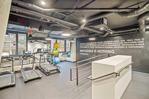 A gym with treadmills and a motivational quote on the wall at Coda on Half Apartments, Washington