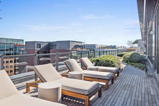 A rooftop patio with wooden furniture and a view of the city at Coda on Half Apartments, District of Columbia