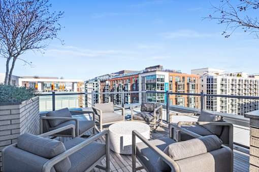 A patio with grey couches and a tree at Coda on Half Apartments, Washington, DC