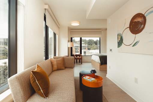 the living room of a hotel suite with a couch and a table at Scout Living, powered by Placemakr Apartments, Atlanta, 30308
