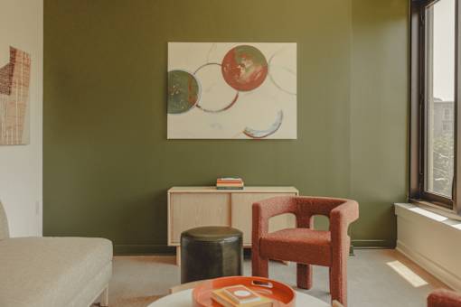 a living room with a chair and a painting on the wall at Scout Living, powered by Placemakr Apartments, Georgia