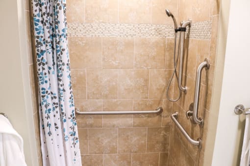a handicap accessible shower in a bathroom with a shower curtain