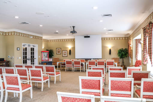 a conference room with rows of chairs and a projection screen