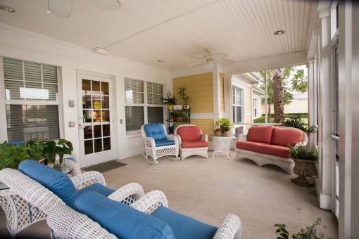 a covered porch with blue and white furniture and chairs