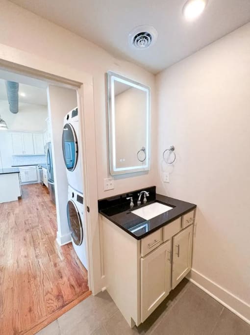 a small bathroom with a sink and a washer and dryer
