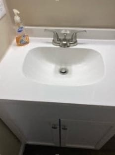 a white sink in a bathroom with a bottle of soap on it