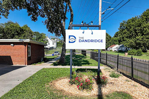 A sign for The Dandridge is in front of a black fence.