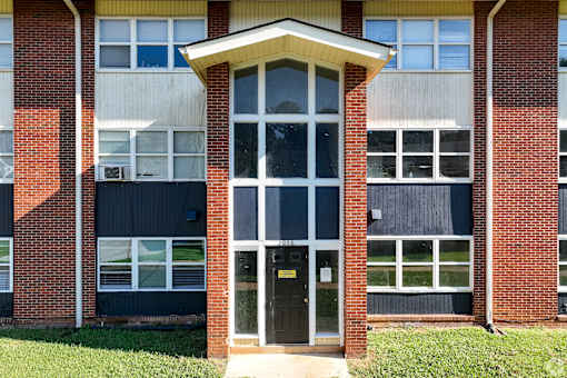 A building with a black door and windows with white frames.