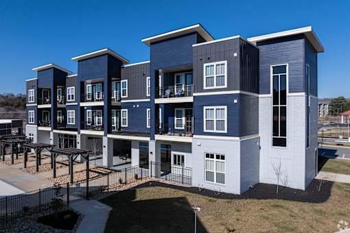 A modern apartment complex with multiple balconies and a mix of blue and grey exterior.