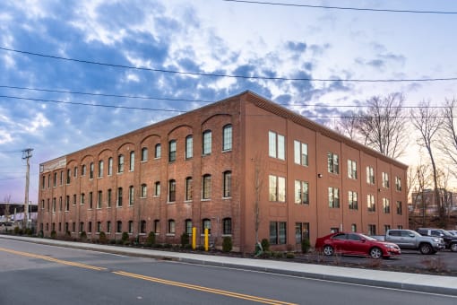 a large brick building with a red car parked in front of it