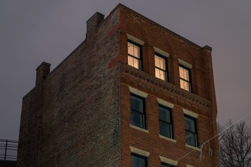 an old brick building with a light on in the window