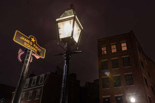 a lamp post with a street sign on the side of it