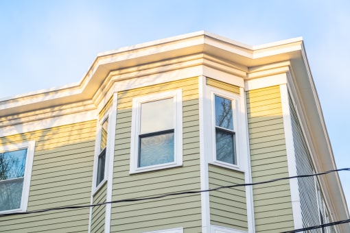a house with green and yellow siding and white trim