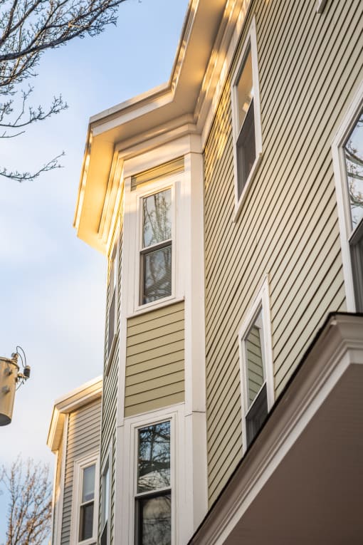 a view of the corner of a house with vinyl siding