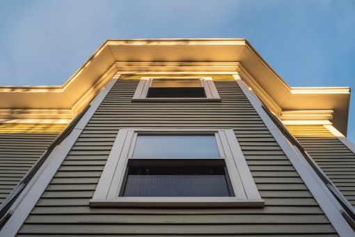 looking up the side of a building with vinyl siding and awning