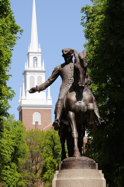 a statue of a man on a horse in front of a church