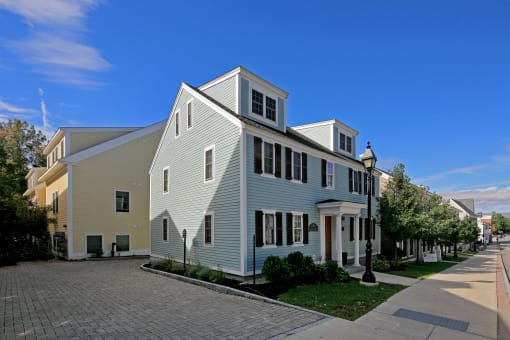 a white house with black shutters and a blue sky in the background