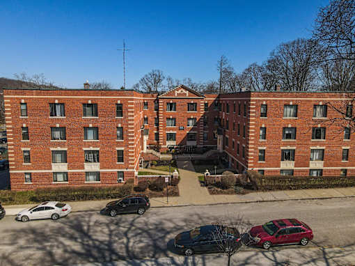 A red brick building with a parking lot in front.