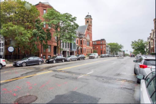 a city street with cars parked on the side of the road