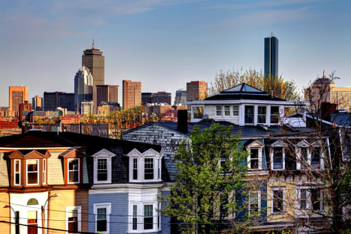 a city skyline with a row of houses in the foreground