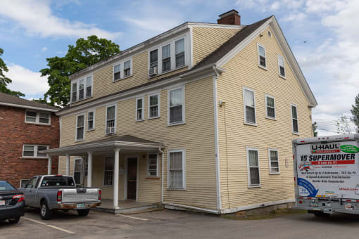 a large yellow house with a truck parked in front of it