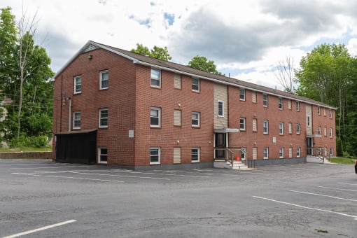 a large brick building with a parking lot in front of it