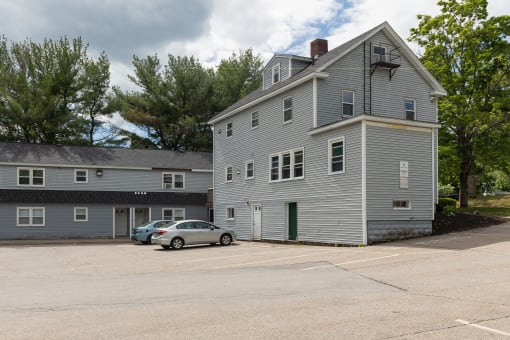a large gray building with a parking lot in front of it