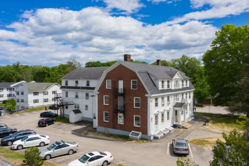 an aerial view of a large red brick building with white trim and a gray roof