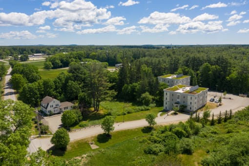 an aerial view of the campus shows the buildings with green roofs and the houses with white roofs