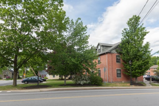 a red brick apartment complex with trees in front of it