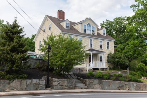 a large house with a stone wall in front of it