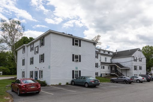 a large white building with a parking lot in front of it