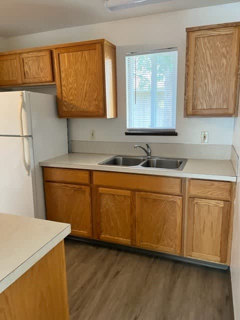A kitchen with wooden cabinets and a white refrigerator.