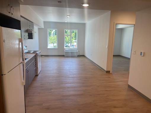 A kitchen with a refrigerator, cabinets, and a countertop.
