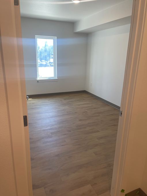 A room with a window and a wooden wall.