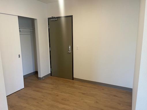 A room with a wooden floor and a metal door.